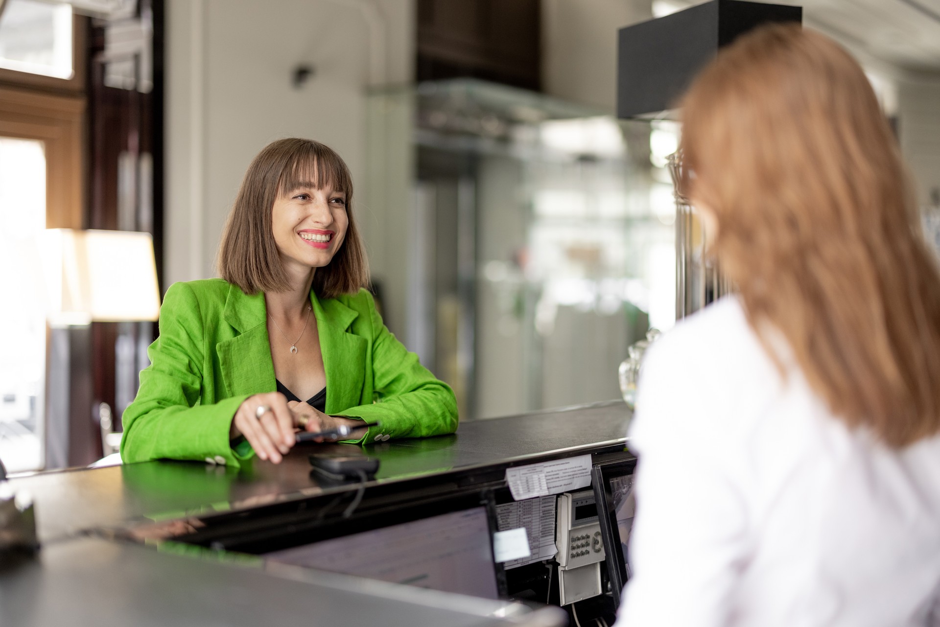 Business woman pays at the hotel reception